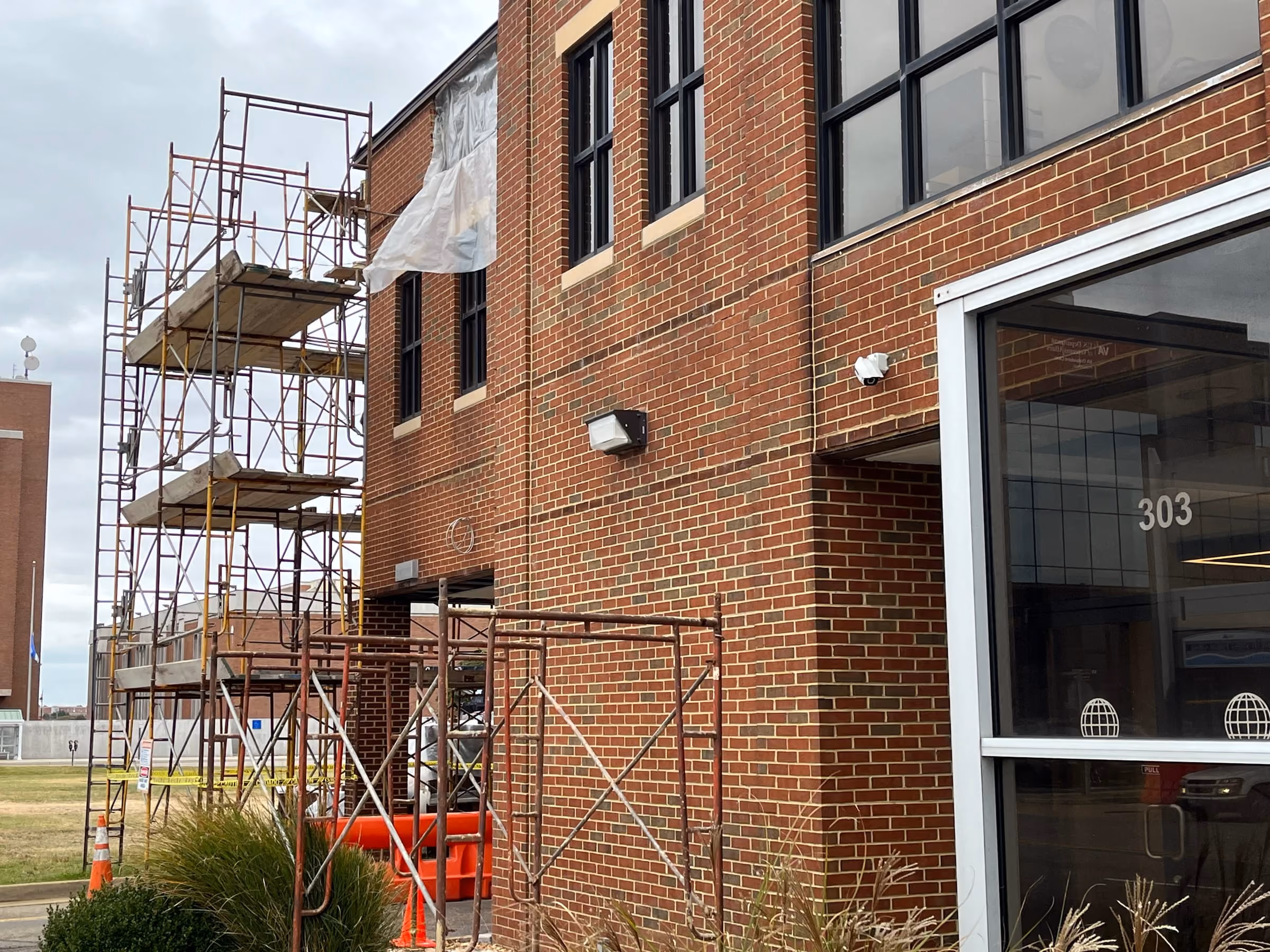 Scaffolding erected against a brick institutional building for exterior restoration work